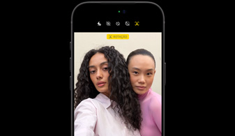 Tela do iPhone 18 Pro preto mostrando duas pessoas com o recurso de rastreamento do rosto, demonstração do funcionamento da câmera frontal Center Stage