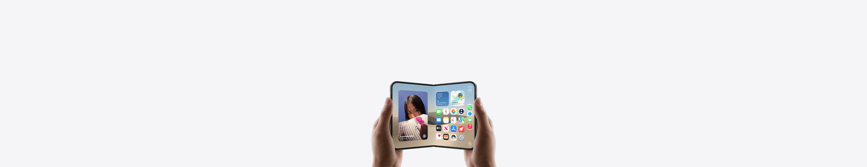 iPhone Duo, deux mains le tiennent en orientation paysage, déplié, l’écran interne affiche l’écran d’accueil