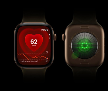 Zwei Apple Watch Series 12 Geräte nebeneinander; Vorderansicht der Apple Watch Series auf der linken Seite, Display zeigt den Herzfrequenzmesser; Rückansicht der Apple Watch Series 12 auf der rechten Seite, helle Lichter leuchten, Farbe Grün