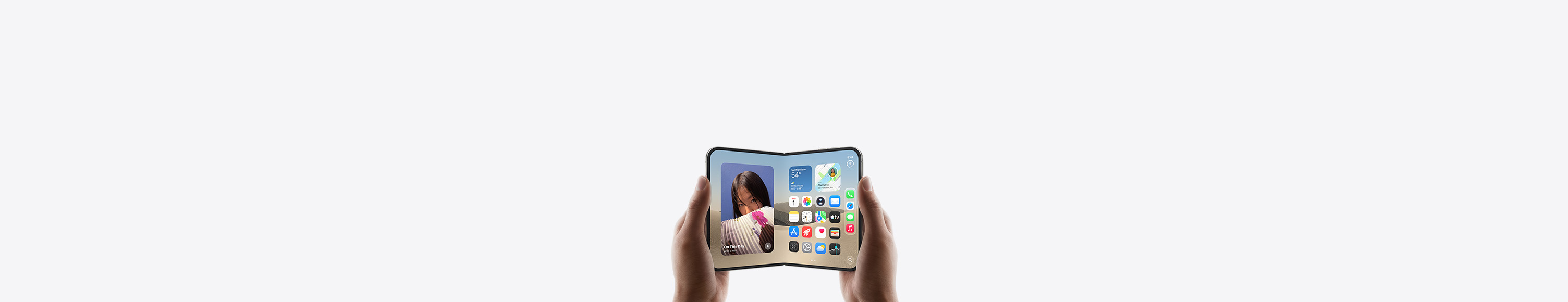 iPhone Duo, held by two hands in landscape orientation, unfolded, interior display features Home Screen