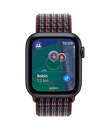 Apple Watch SE 3, aluminium case, midnight colour, screen shows Find My app (memojis on a map background), right side exterior, Digital Crown dial, Sport Loop strap, burgundy plaid colour