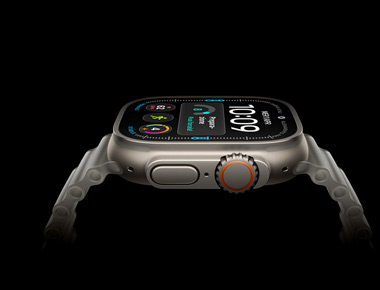 Apple Watch Ultra 4 mostrato di lato, cassa in titanio color argento, il display mostra un quadrante digitale e alcuni parametri su salute e fitness; sul lato si notano il tasto laterale e la Digital Crown arancione