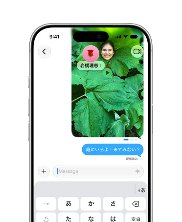 画面に、メッセージアプリで送信されている、葉の多い植物の中でポーズをとる人物の写真が表示されている。送信インジケータのステータスバーには送信の進行状況が表示され、画像の下部には送信したメッセージがあり、「庭にいるよ！来る？」のテキストが書かれている
