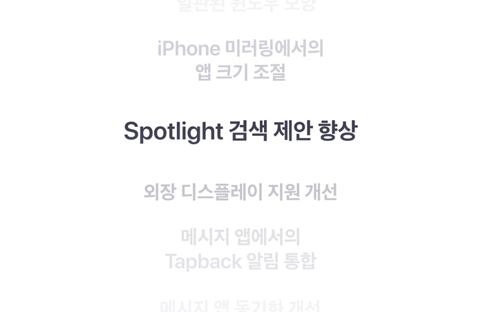 특징들이 세로로 나열되어 있고, 그중 ‘Spotlight 검색 제안 향상’이 중앙에서 굵은 글씨로 표시된 모습. 위아래에 있는 주변 특징들은 배경 속으로 점점 희미해져 보입니다.