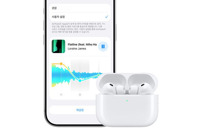 iPhone 18 Pro 앞면과 그 옆에 놓인 Apple AirPods Pro 3 화이트 색상 충전 케이스 모델의 모습. 열려 있고 안의 이어버드가 보입니다.
