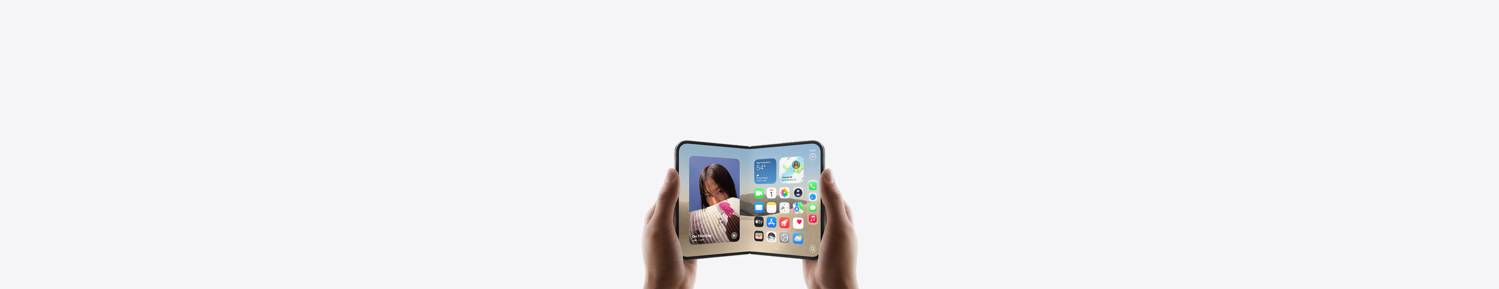 iPhone Duo, dos manos lo sostienen en posición horizontal, desplegado, la pantalla interior muestra la pantalla de inicio