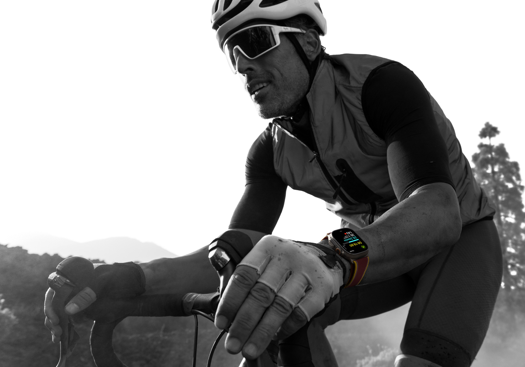 Osoba z Apple Watch Ultra 4 jadąca na rowerze, na ekranie widać parametry jazdy na rowerze