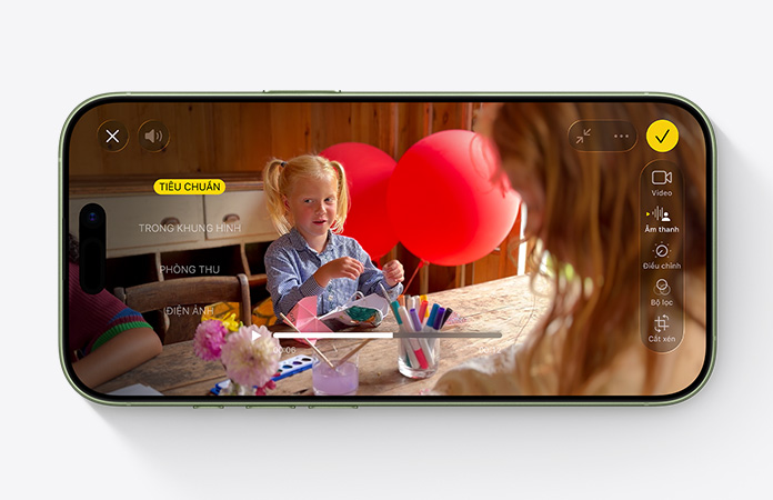 iPhone 17, vỏ ngoài mặt trước, video sử dụng tính năng Hòa Âm quay một em nhỏ đang chơi trên bàn với các quả bóng bay